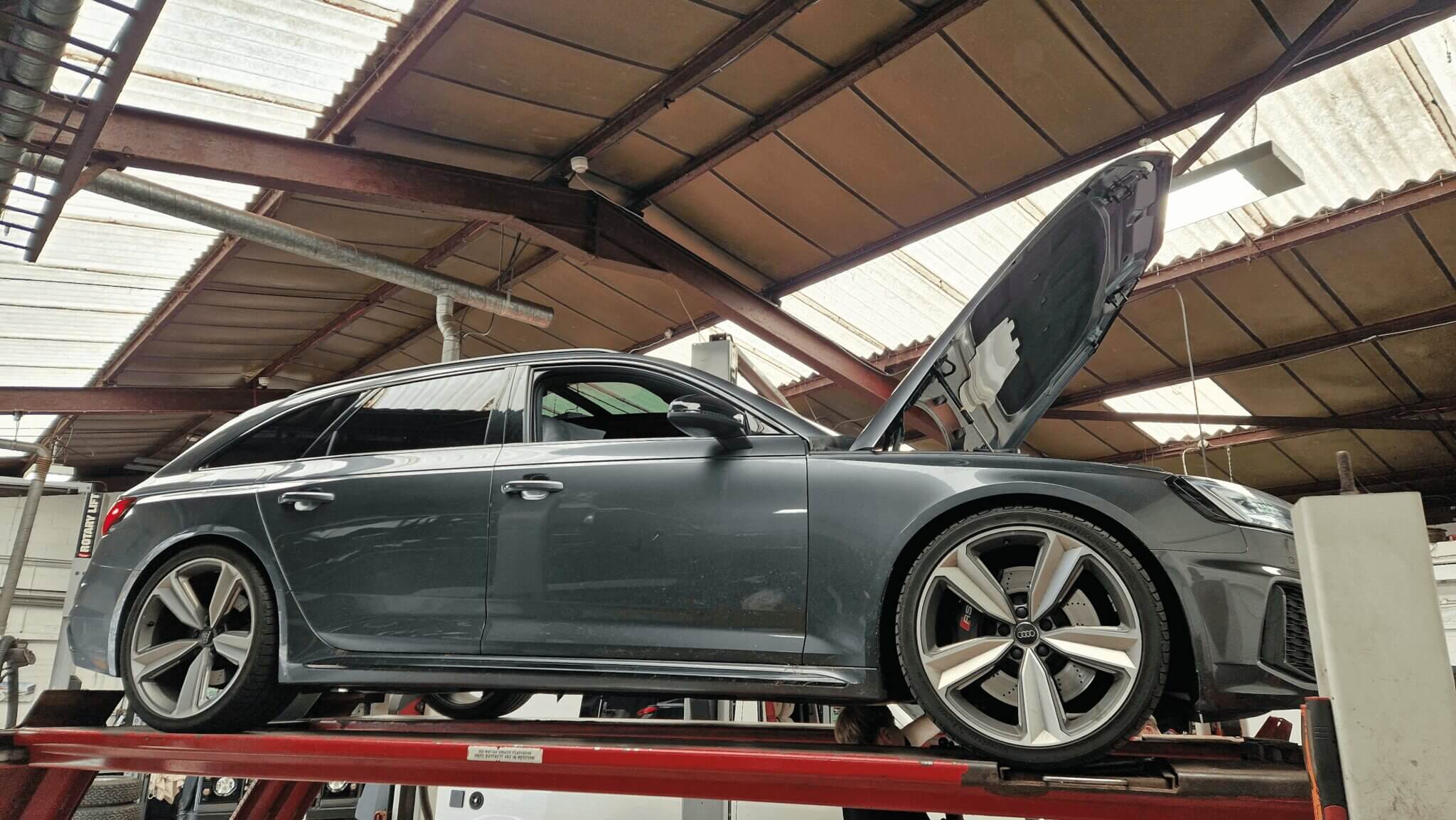 Grey Audi with bonnet open on tracks